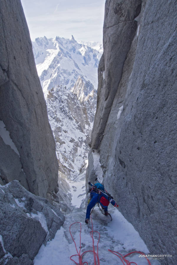 Ally tops out from the second pitch, Jorasses in the background